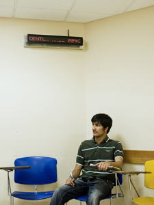 A student sits underneath an installed LED digital sign