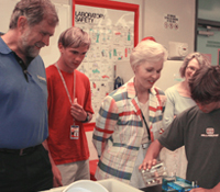 Jacobs School dean Frieder Seible and former California first lady Gayle Wilson observe a COSMOS stu