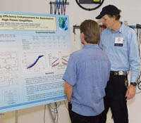 Calit2 engineer Don Kimball (right) explains the power amplifier breakthrough to a visitor during th