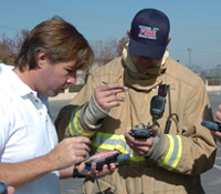 Calit2 researcher coaches firefighter on new PDA application for emergency response.