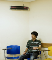 A student sits underneath an installed LED digital sign