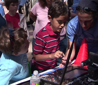 At Calit2 booth, kids learn the basics about remote-controlled vehicles for disaster response