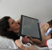 A doctor in Mozambique uses a tablet-based ultrasound developed by the DH Lab to analyze a patient. 