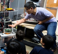 Tingfan Wu shows the RUBI robot to a group of elementary students visiting the Qualcomm Institute th