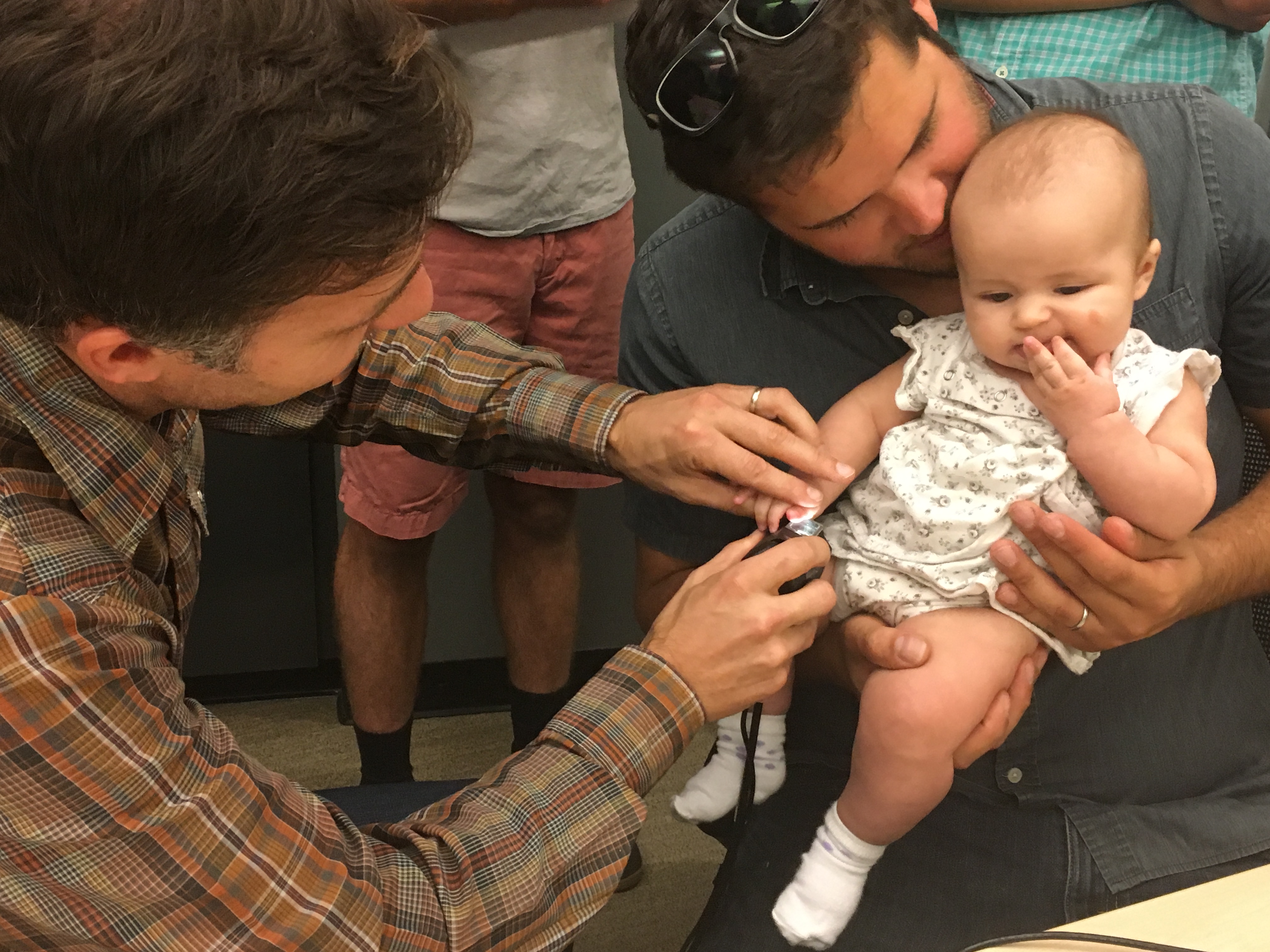 Baby being having her fingerprint scanned 