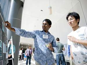Keddar Reddy explains his poster to a visitor to the Poster Session.
