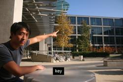 Kai Wang, a UC San Diego computer science graduate student and an author on the key duplication paper, points to the roof where researchers photographed and decoded keys sitting on a table at the cafe where he now sits.